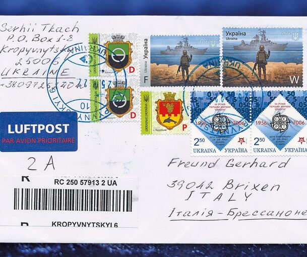 Auf einem nach Italien adressierten Briefumschlag aus der Ukraine kleben sieben Briefmarken. Auf zwei dieser Marken ist ein Krie