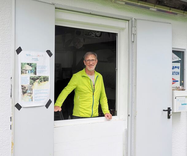 Vereinsmitglied Martin Schneider zeigt, wie hoch das Wasser im Vereinsheim stand.