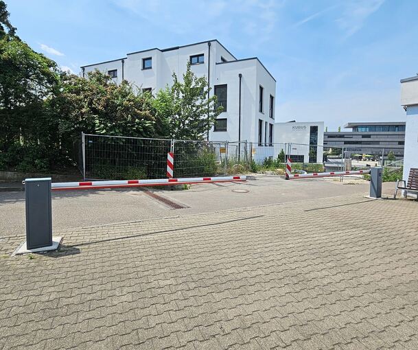 Weil auf seinem Grundstück immer wieder Baufahrzeuge abgestellt wurden, hat ein Nachbar eine Schranke anbringen lassen. Im Hintergrund ist eines der beiden unfertigen Häuser zu sehen.