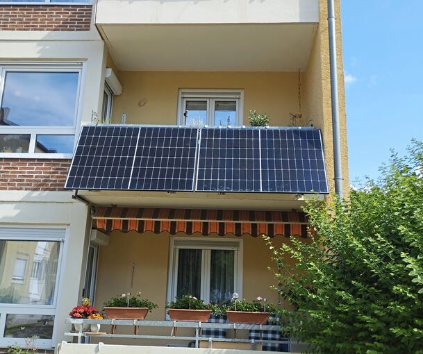 Eine Balkon-Solaranlage hängt an einem Balkon.