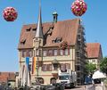Die jüngst aufgehängten Blumenbälle sind ein echter Blickfang – und vielleicht eine gute Alternative zum Rathaus, das nach und nach eingerüstet wird.