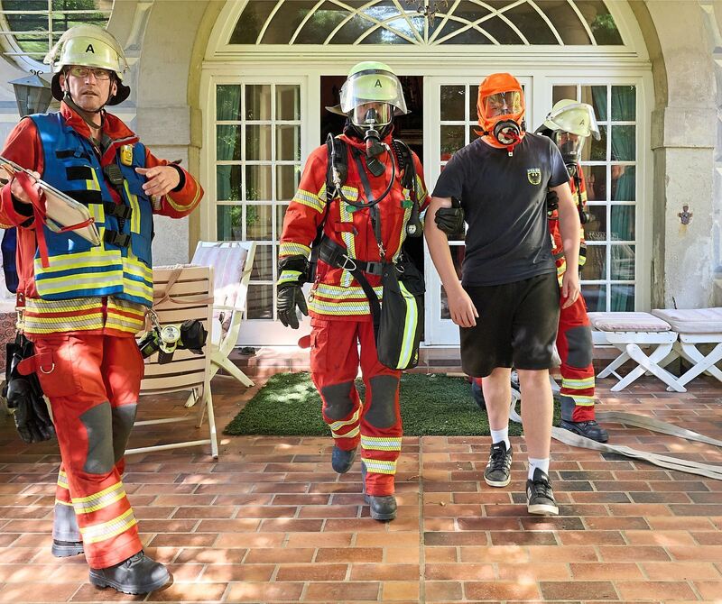 Mit Masken gegen den möglicherweise giftigen Rauch.