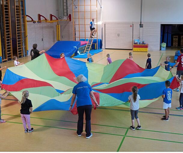Fallschirm nennt sich dieses Tuch, das die Kinder des evangelischen Kindergartens Schimmelfeld am Donnerstag bei „Kiga-Fit“ auf- und niederwehen ließen.