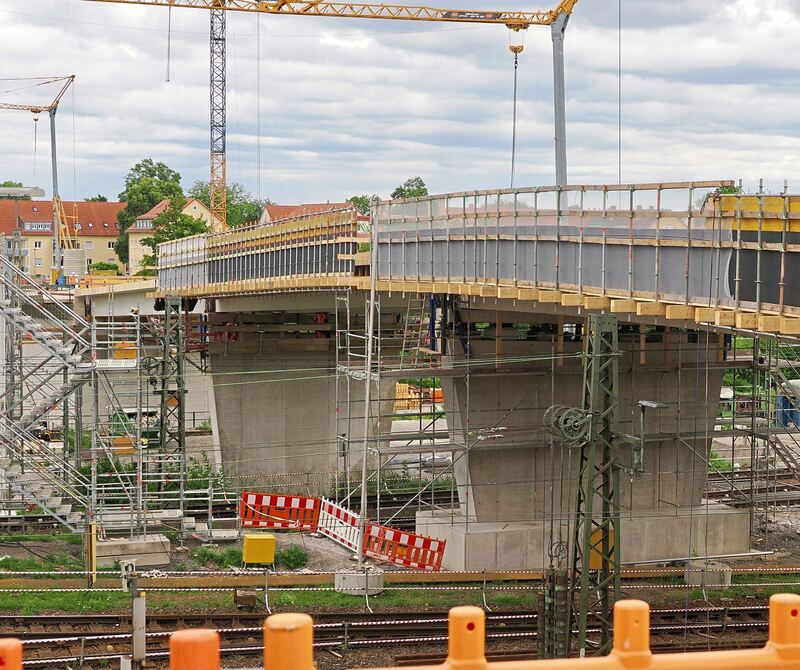 Die Brücke spannt sich über die Bahngleise.