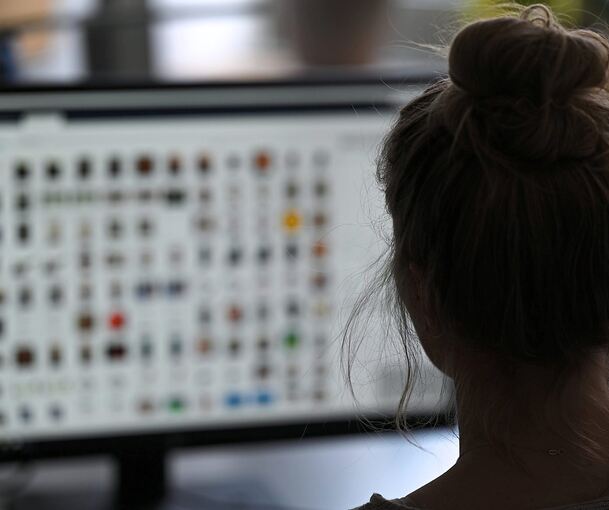 Eine Kriminaloberkommissarin sitzt in einem Büro vor einem Auswertungscomputer auf der Suche nach Kinderpornografie und Fällen von sexuellem Missbrauch.