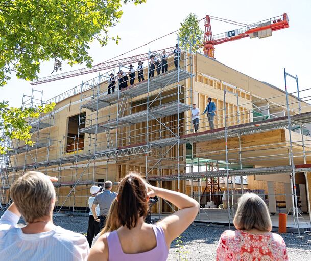 Nach den kurzen Reden von Bürgermeister und Architekt (rechts) hielt Zimmerer Lucas Pfeiffer den Richtspruch und zerschmetterte anschließend sein Weinglas auf dem Gerüst.