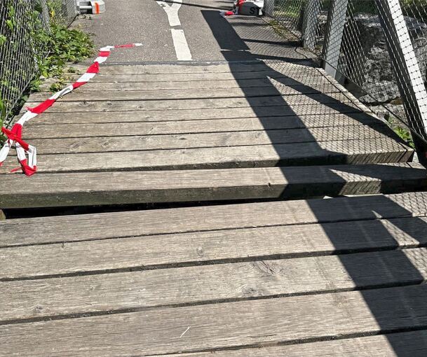 Ein Holzbalken ist von Unbekannten aus der Radfahrer- und Fußgängerbrücke gerissen worden. Dadurch entstand eine gefährliche Lücke.