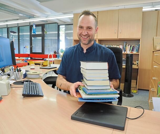 Lutz Schützler führt die neue Sammelverbuchung vor. Für die Ausleihe muss nicht mehr jedes einzelne Buch gescannt werden. Es reicht, den Stapel auf Gerät zu legen.