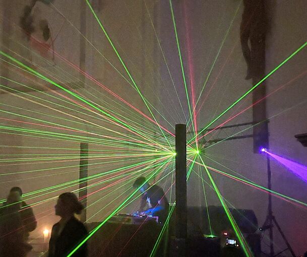 Der DJ steht am Freitagabend unter dem Kruzifix.