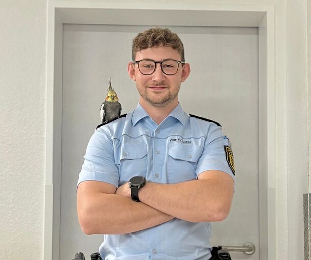 Der zutrauliche Nymphensittich macht es sich auf der Schulter eines Polizisten bequem.