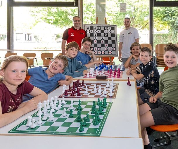 Florian Schlachter (hinten links) und Julian Leidel (rechts) geben den jungen Schachspielern Anleitung.