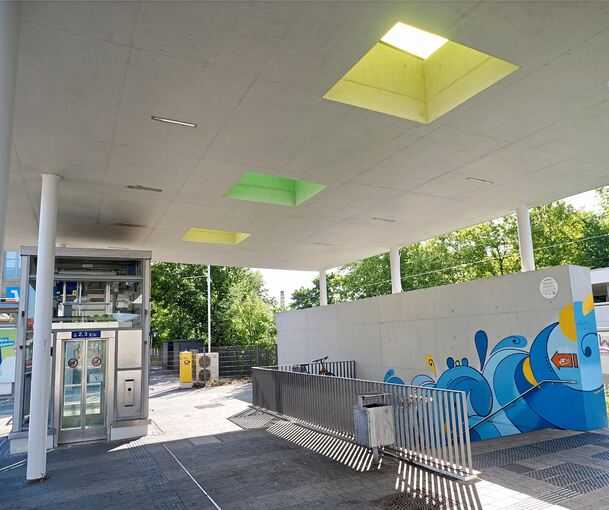 Die Treppe ist ebenso bunt bemalt wie die Unterführung. Einen Aufzug gibt es nur auf der nördlichen Bahnhofseite.