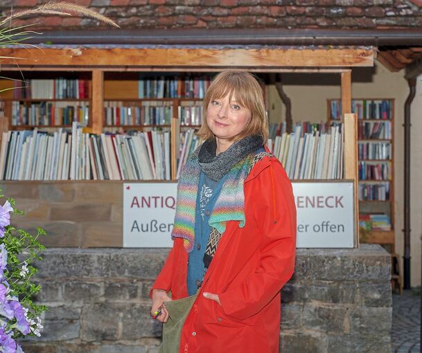 Organisatorin Anna Matysik steht vor dem Außenbereich des Antiquariats in Hoheneck.