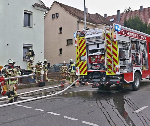 Über ein gekipptes Fenster dringen Feuerwehrleute in die Erdgeschosswohnung ein.