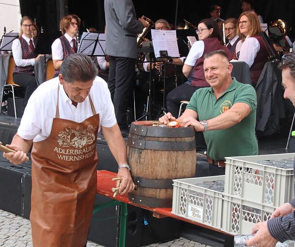 Eberhard Zucker beim Fassanstich zum Vaihinger Straßenfest. Die Musiker aus Kleinglattbach sind gespannt. Eine Blinddichtung bremste den Stadtrat aus. Doch nach 26 Schlägen klappt es.