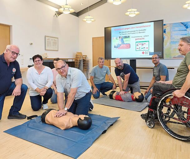 Hans Müller und Heike Müller-Bartruff vom DRK (von links) haben erklärt, wie es geht. Nun ist Bürgermeister Uwe Seibold mit der Herzdruckmassage am Dummie an der Reihe.