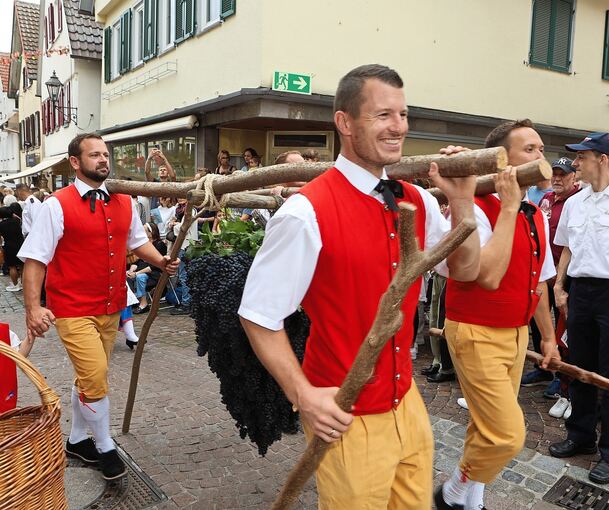 Vier Männer tragen beim Festumzug die Kalebstraube durch die Kirchstraße.