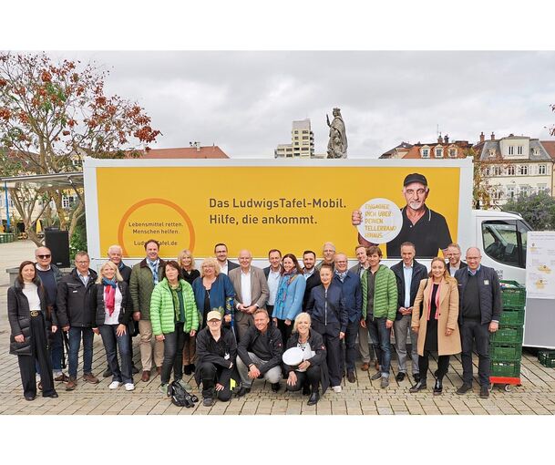 Gruppenbild mit LudwigsTafel-Mobil: Zur Einweihung am Dienstag auf dem Marktplatz gesellen sich zu Tafel-Geschäftsführer Hergen Blase (kniend, Mitte) und Vorsitzender Uschi Eberwein (1. Reihe links, blaue Jacke) zahlreiche (Ober-)Bürgermeister, Spons