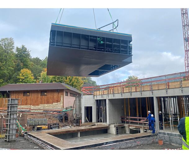 Das Freiluft-Schwimmbecken in der Luft, bevor es mit dem Kran auf seinen Platz balanciert wird.