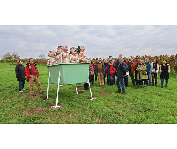 Künstler Otto Beer hat die Holzskulptur erschaffen, die auf einer Wiese mitten in den Reben thront und schmunzeln sowie rätseln lässt.