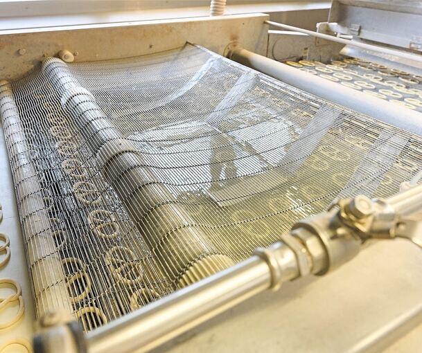 Die Brezeln werden ins Laugebad getaucht, bevor es weiter in den Backofen geht.