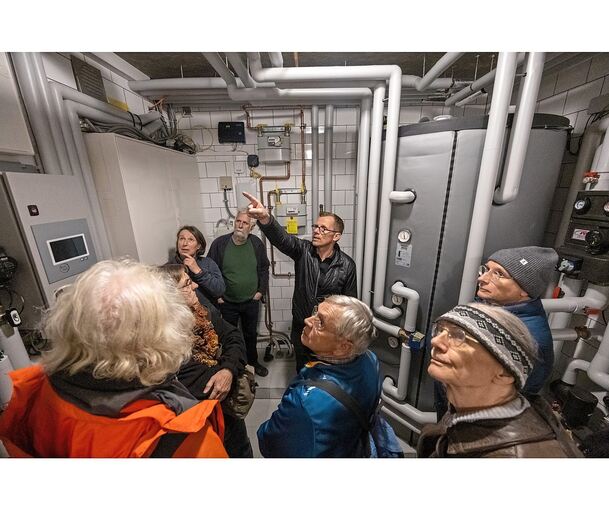 Der Vaihinger Oberbürgermeister Uwe Skrzypek erklärt den Teilnehmern des Spaziergangs im Technikraum seines Hauses die Funktion seiner Heizung.