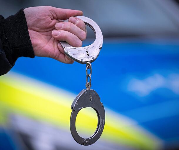 Ein Polizist mit Handschellen. Ein Polizist mit Handschellen.