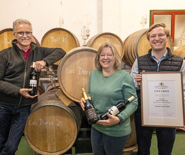 Im Weinberg und Keller ein Team: Dietmar und Silvia Ott mit ihren Weinen, Sohn Benjamin mit der Urkunde für den Staatsehrenpreis.