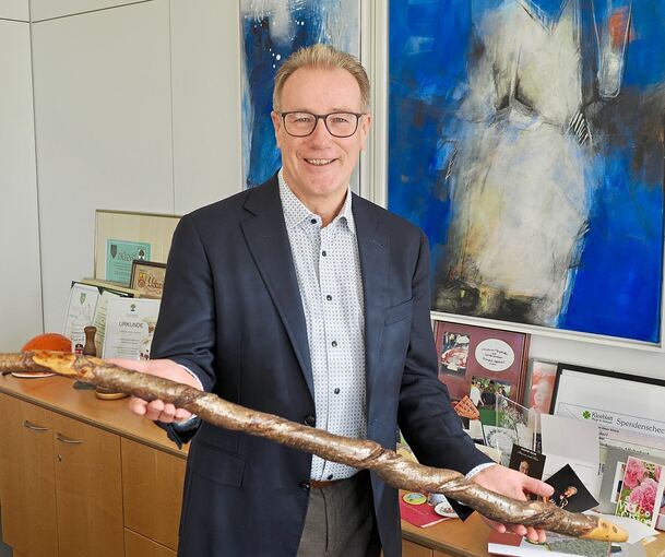 Auf dem Sideboard hat Steffen Döttiner all die Geschenke versammelt, die er in 25 Jahren bekommen hat. Darunter ein geschnitzter Wanderstock von einem Bürger.