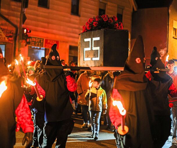 Die Kirbebuben tragen den Kirbesarg 2025 zum Neckar, wo er verbrannt wird.