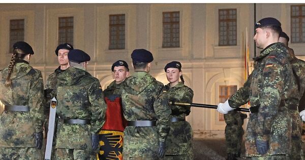 Abordnungen der 250 Rekrutinnen und Rekruten geloben an der Truppenfahne, Deutschland zu dienen.