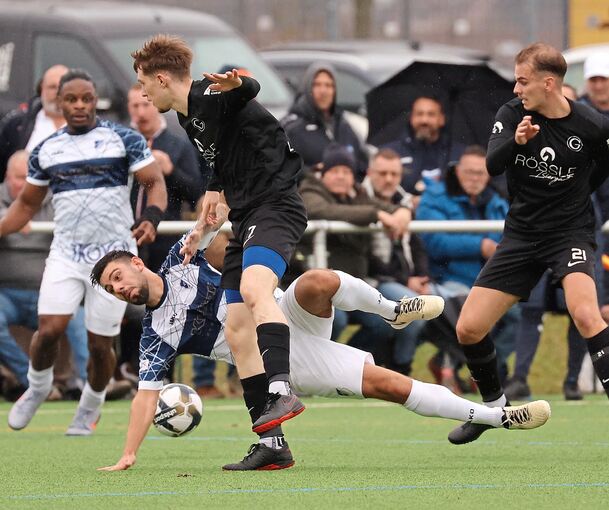 Münchingens Antonio Di Matteo (unten) kommt auf schwierigem Geläuf im Zweikampf mit Sven Larisch zu Fall.
