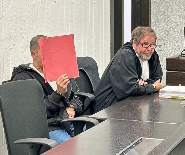 Der Angeklagte verbirgt sein Gericht, neben ihm sein Verteidiger.