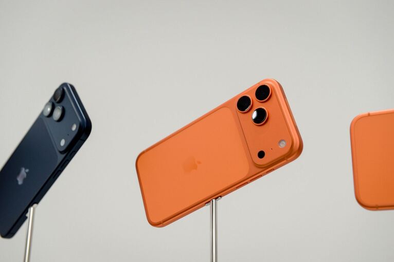 Apple iPhone Pro in den Farben Tiefblau und Cosmic Orange