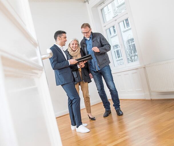 Ein Makler zeigt Interessenten eine Immobilie. Künstliche Intelligenz kann in der Branche helfen - hat aber auch seine Grenzen.