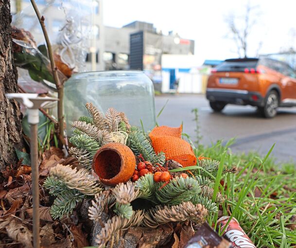 An der Unfallstelle, wo die zwei jungen Frauen starben, sind Gestecke abgelegt. Im Hintergrund ist die Aral-Tankstelle zu sehen, aus der sie mit dem Kleinwagen fuhren.