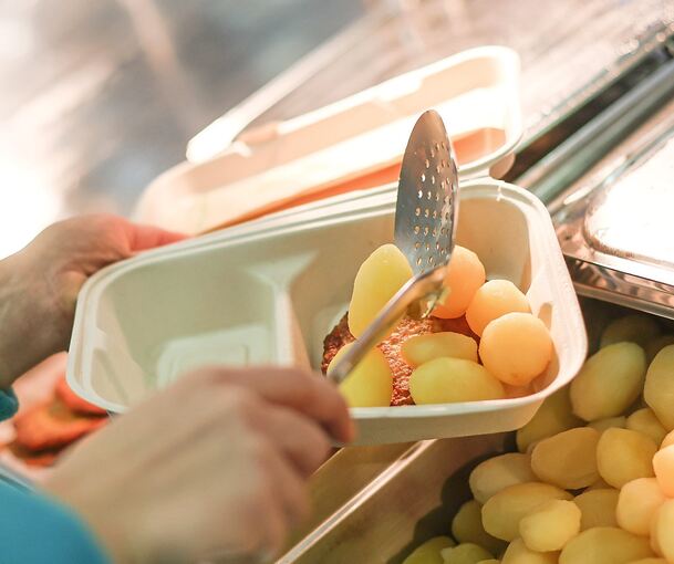 Wenn es an Spitzentagen zu Stoßzeiten keine freien Sitzplätze in den Mensen gibt, füllt das Mensa-Personal die Speisen in Einwegboxen.