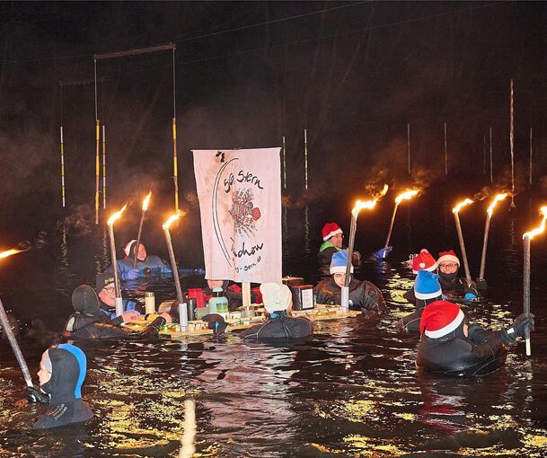 Rund 70 Taucher steigen beim Fackelschwimmen in Bietigheim in die fünf Grad kalte Enz.