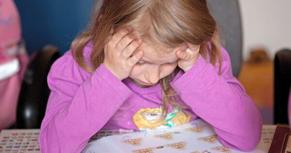 Ein Grundschulkind grübelt über seinen Matheaufgaben.