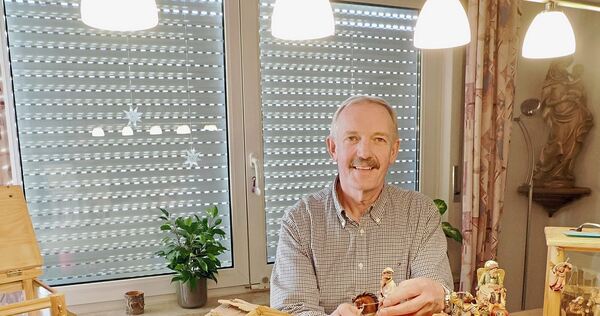 Andreas Lenz in seinem Wohnzimmer. Vor ihm ein kleiner Teil seiner Krippensammlung.