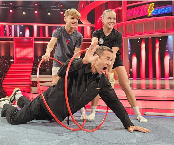 Ben und Zoe führen mit Moderator Kai Pflaume und gleich zwei Reifen vor, wie die Übung abläuft.