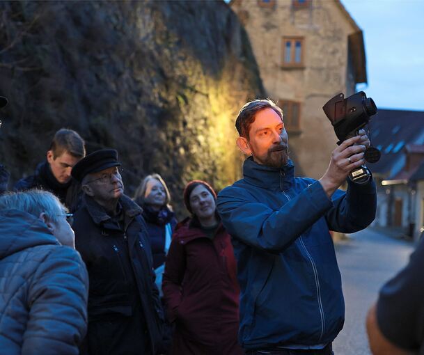 Mit der Wärmebildkamera zeigt Energieberater Florian Kamp den Teilnehmern des Spaziergangs, wo die Schwachstellen der Gebäude liegen.