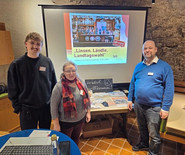 Die Organisatoren Nico Oesterwind, Corinna Rauch und Michael Volz vor der Präsentationswand.