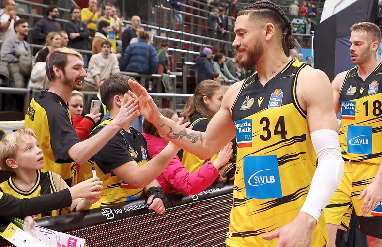 Erstkontakt mit den Riesen-Fans: Gavin Schilling bei der Ehrenrunde nach dem Spiel gegen Bonn, rechts Jonas Wohlfarth-Bottermann.