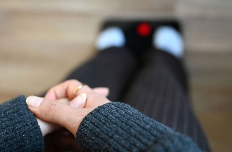 Jugendliche steht auf Waage Jugendliche steht auf Waage