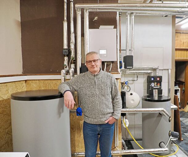 „Am Anfang war ich skeptisch hoch zehn“: Wolfgang Gerne lehnt am Pufferspeicher in seinem Heizungskeller.