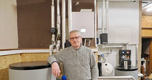 „Am Anfang war ich skeptisch hoch zehn“: Wolfgang Gerne lehnt am Pufferspeicher in seinem Heizungskeller.