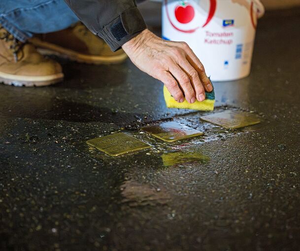 Mit Schwamm und Politur werden die Stolpersteine sichtbar gemacht.