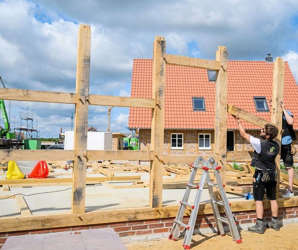 Zimmerer errichten ein selbsttragendes Fachwerkhaus aus Eichenbalken. Die Kosten für eine Handwerkerstunde setzen sich aus verschiedenen Posten zusammen. Wichtig zu wissen: Der Stundenverrechnungssatz ist nicht gleich der Stundenverdienst eines Handw