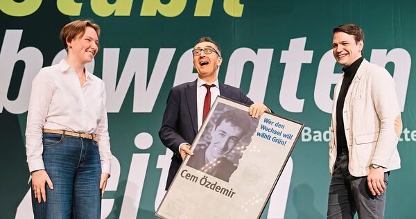Kinder, wie die Zeit vergeht: Die Kreisvorstandsmitglieder Amelie Kalt und Lars Schweizer (rechts) überreichen Cem Özdemir auf dem Parteitag im Forum im Dezember ein Wahlplakat aus dem Jahr 1994.